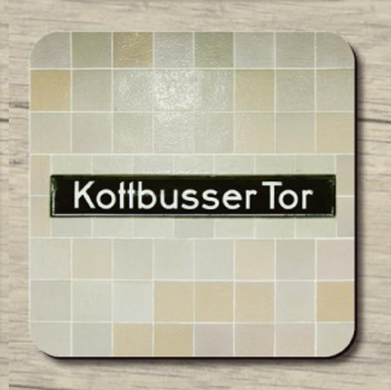 U-Bahnhof Kottbusser Tor - weiße Schrift auf schwarzem Schild auf beige/grauen Fliesen