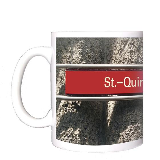 U-Bahnhof St.-Quirin-Platz Kaffeetasse - weiße Schrift auf blauem Schild, vor Betonsäulen-Wand