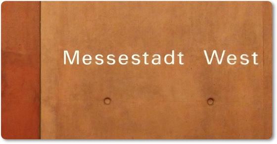 U-Bahnhof Messestadt West - weiße Schrift auf orange-braunem Hintergrund mit vereinzelten Vertiefungen