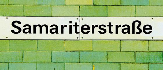 U-Bahnhof Samariterstraße Kaffeetasse - schwarzes Schild mit weißer Schrift auf grün-gelber Fliesenwand