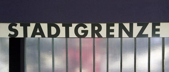U-Bahn-Tasse Stadtgrenze in Fürth der Nuernberger Linie U1 in der originalgetreuen Stations-Gestaltung - oberirdische Drahtglaswand mit schwarzer Schrift auf weissem Schild - von aussen durchscheinende Lichtreflexe