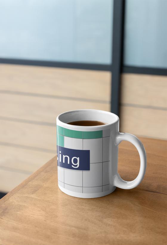 S-Bahnhof Pasing Kaffeetasse - dunkelblaues S-Bahnschild mit weißer, serifenloser Schrift, vor weißer Fliesenwand mit vereinzelten grünen Fliesen