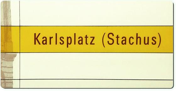 U-Bahnhof Karlsplatz Stachus Kühlschrankmagnet - schwarzer Schrift auf gelbem Streifen, vor weißem Plattenhintergrund 