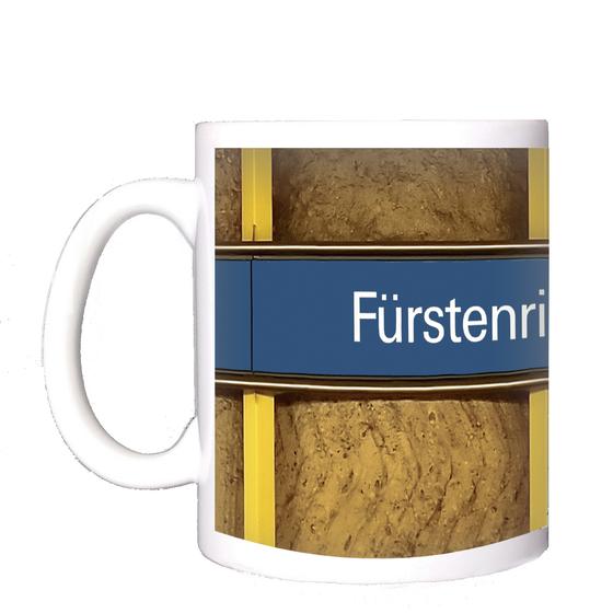 U-Bahnhof Fürstenried Kaffeetasse - weiße Schrift auf blauem Schild, vor braunem Hintergrund mit Holzstruktur und gelben Senkrechtbalken