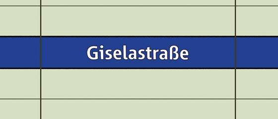 U-Bahnhof Giselastraße Kaffeetasse - weiße Schrift auf blauem Streifen, vor weißem Plattenhintergrund