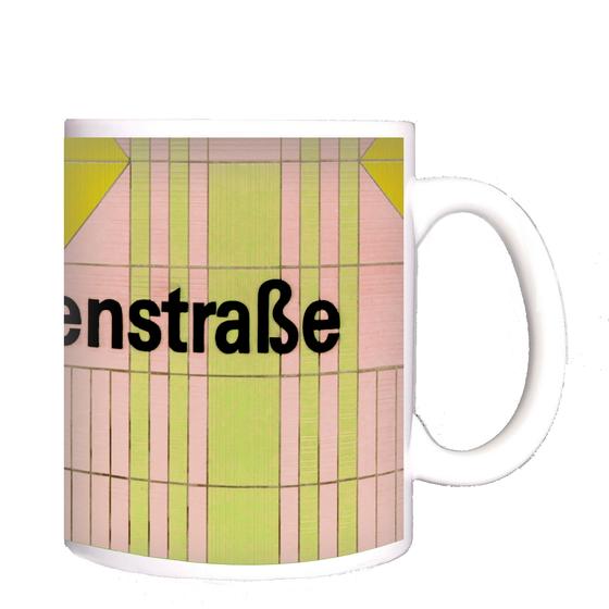 U-Bahnhof Kurfürstenstrasse Kaffeetasse - schwarzer Schrift auf rosa-grün gestreifter Kachelwand mit gelbem Quadrat