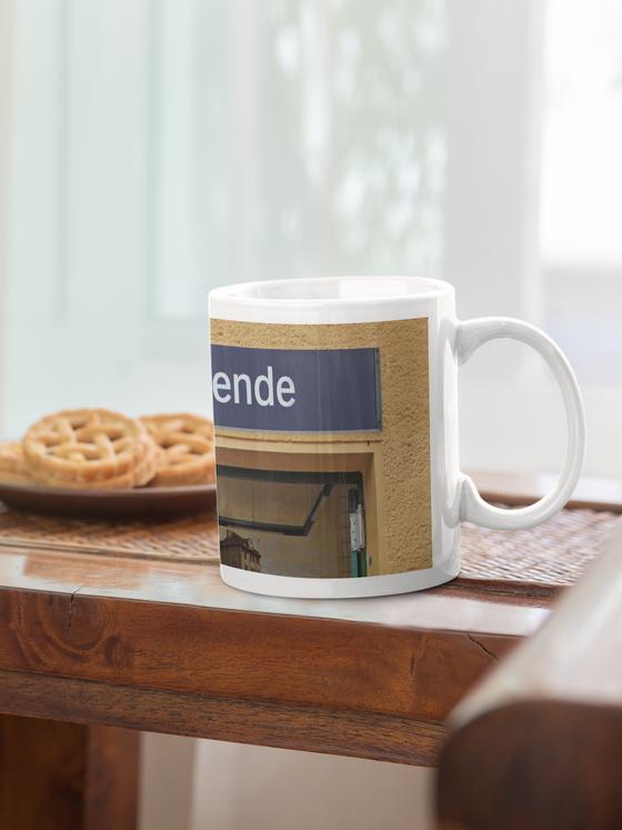 S-Bahnhof Südende S26 Kaffeetasse - weisse Schrift auf blauem Schild über Eingangstür - Umrahmt von beige-brauner Rauputz-Wand