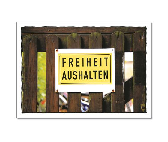 Klassische Postkarte - An einem Holzzaun haengt ein Schild mit der Aufschrift Freiheit aushalten. 