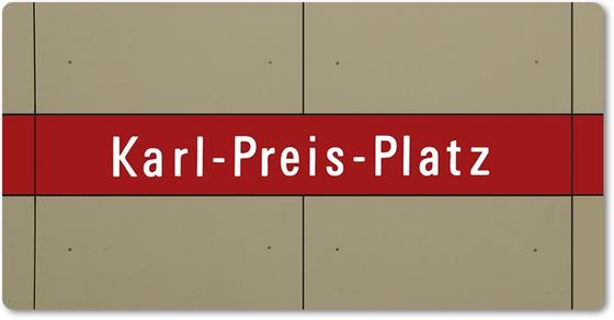 U-Bahnhof Karl-Preis-Platz Kühlschrankmagnet - weiße Schrift auf dunkelrotem Streifen, vor grau-brauner Plattenwand