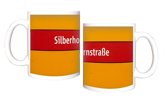 U-Bahnhof Silberhornstraße Kaffeetasse - weiße Schrift auf rotem Streifen, vor dunkelgelbem Hintergrund