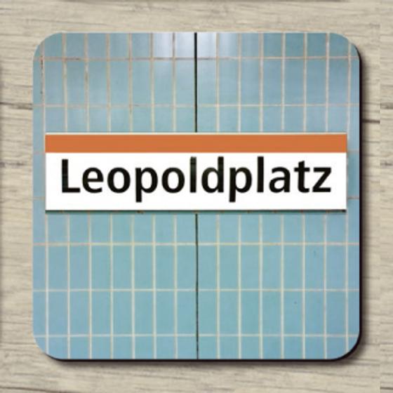 U-Bahnhof Leopoldplatz - schwarze Schrift auf weißem Schild mit orangenen Streifen auf hellblauen Fliesen