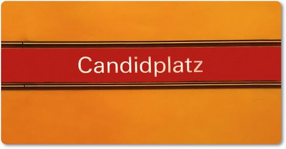 U-Bahnhof Candidplatz Kühlschrankmagnet - weiße Schrift, auf rotem Streifen, schwarz umrandet, vor gelb-orangem Untergrund