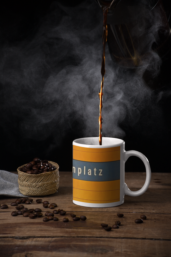 U-Bahnhof Marienplatz Kaffeetasse - weiße Schrift auf blauem Schild, vor orangem Hintergrund