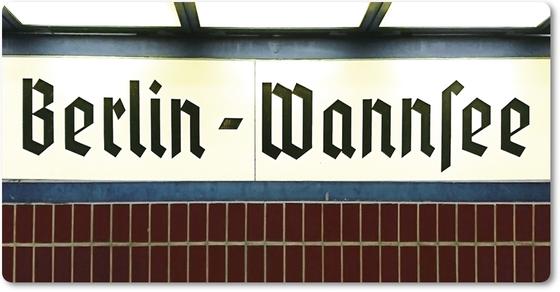 S-Bahnhof Wannsee - schwarze Schrift auf weißem Schild darunter dunkelrote Fliesen