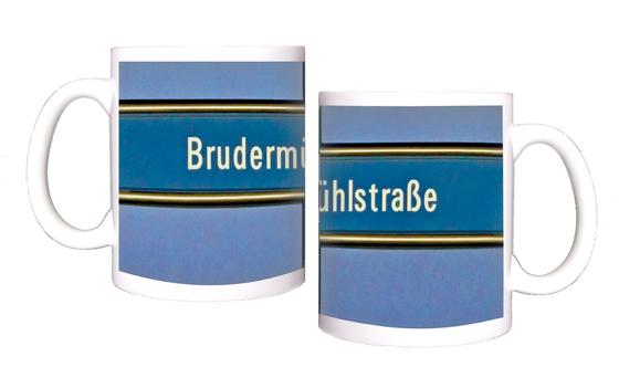 U-Bahnhof Brudermühlstraße Kaffeetasse - weiße Schrift auf blauem Schild, gelb umrandet, vor fliederfarbenem Untergrund