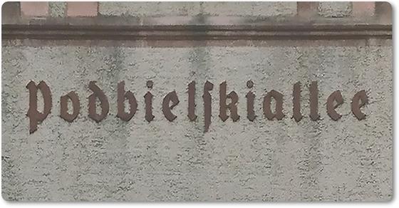 U-Bahnhof Podbielskiallee - dunkel-braune Frakturschrift auf grauem Beton
