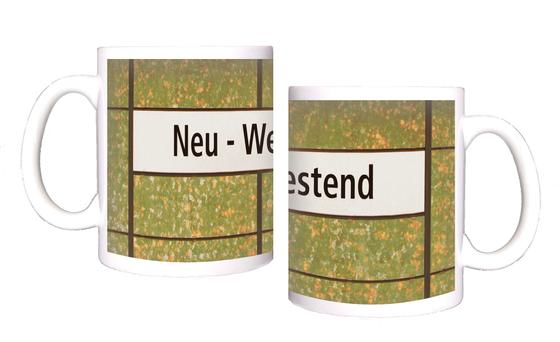 U-Bahnhof Neu-Westend Kaffeetasse - schwarze Schrift auf weißem Schild, vor grün-orange-weiß getupfter Wand