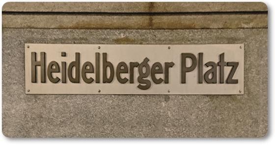 U-Bahnhof Heidelberger Platz Kühlschrankmagnet - schwarze Schrift auf weißem Schild vor grauer Betonwand