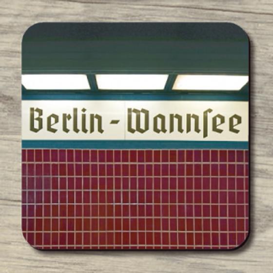 S-Bahnhof Wannsee - schwarze Schrift auf weißem Schild darunter dunkelrote Fliesen