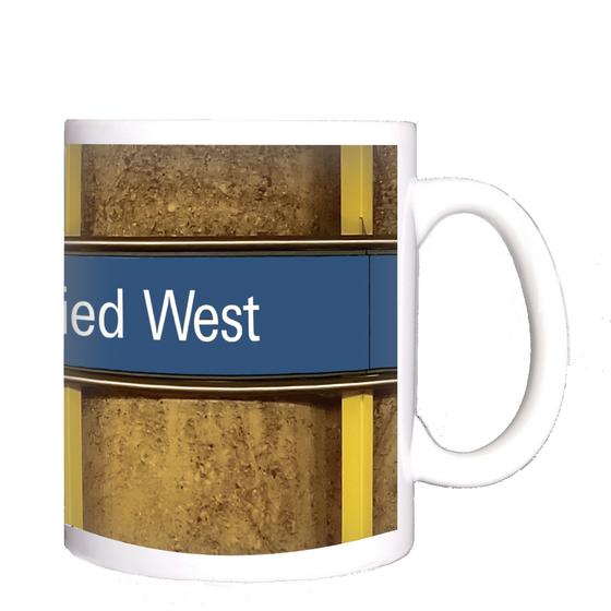 U-Bahnhof Fürstenried Kaffeetasse - weiße Schrift auf blauem Schild, vor braunem Hintergrund mit Holzstruktur und gelben Senkrechtbalken