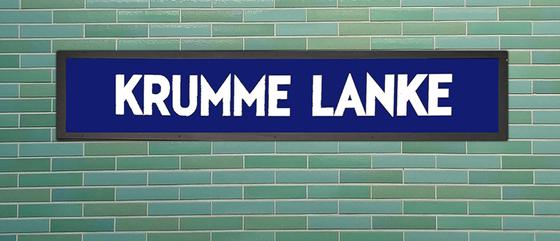 U-Bahnhof Krumme Lanke Kaffeetasse - weiße Schrift auf blauem Schild, vor grün-blauer Fliesenwand