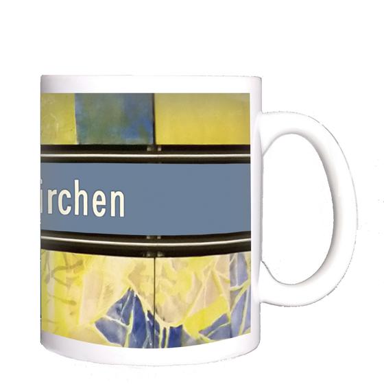 U-Bahnhof Thalkirchen Kaffeetasse - weiße Schrift auf blauem Schild, mit schwarzer Umrandung, auf abstraktem Muster in blau-gelb