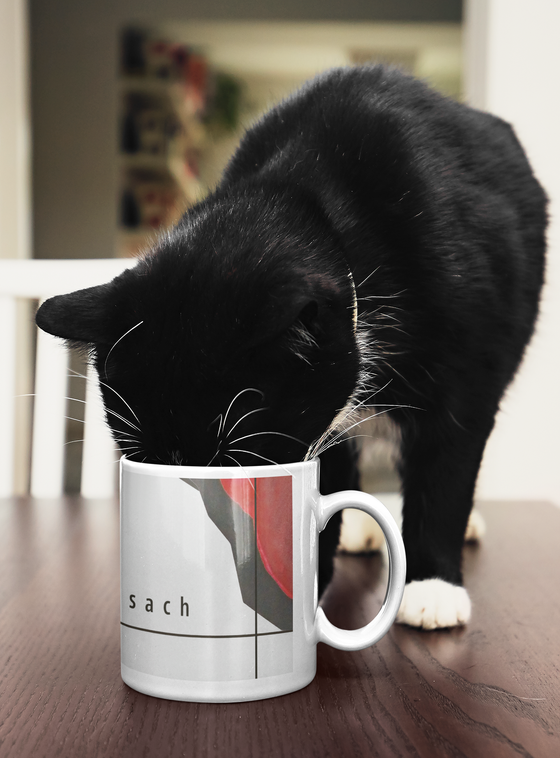 U-Bahn Tasse Moosach - schwarze Schrift auf weißem Hintergrund mit rot-schwarzen, abstrakten Steinformen