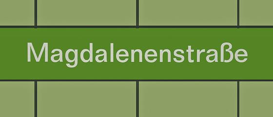 U-Bahnhof Magdalenenstraße Kaffeetasse - weiße Schrift auf grasgrünem Streifen vor waldgrünem Hintergrund, mit schwarzen Fugen
