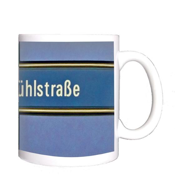 U-Bahnhof Brudermühlstraße Kaffeetasse - weiße Schrift auf blauem Schild, gelb umrandet, vor fliederfarbenem Untergrund