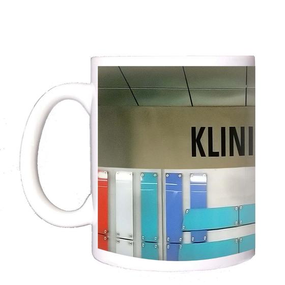 U-Bahn-Tasse Fuerth Klinikum der Nuernberger Linie U1 in der originalgetreuen Stations-Gestaltung - grau-beiges Schild mit schwarzer Schrift, an der Rückwand farbige, brettartige Panelen als Gestaltungselemente