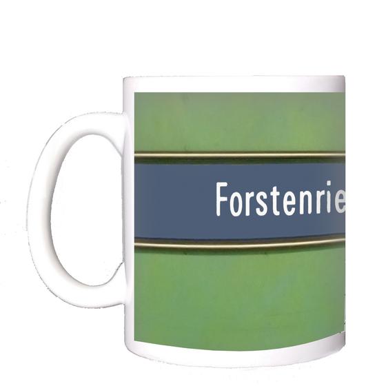 U-Bahnhof Forstenrieder Allee Kaffeetasse - weiße Schrift auf blauem Streifen, mit goldener Umrandung, vor grünem Hintergrund
