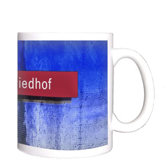 U-Bahnhof Westfriedhof Kaffeetasse - rote Schrift auf rotem Schild, vor blauem Hintergrund mit Farbverlauf und mittigem Spalt