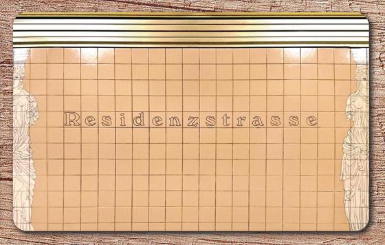 U-Bahnhof Residenzstraße Schneidebrettchen - schwarz umrandete, serifenbetonte Schrift auf beigem Fliesenhintergrund