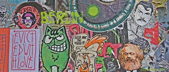 Klassischer Kaffeebecher aus weisser Keramik mit einem Foto einer bunten Streetart-Wand mit Berlin-Schriftzug in Berlin Friedrichshain - beklebt und bemalt von vielen verschiedenen Künstlern 