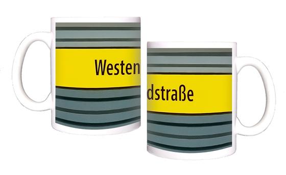 U-Bahnhof Westendstraße Kaffeetasse - schwarzer Schrift auf gelbem Schild, vor grau-blauer Wand mit schwarzen Streifen