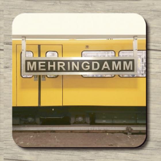U-Bahnhof Mehringdamm - schwarzes Schild mit heller Schrift im Hintergrund Berliner U-Bahn (gelb)