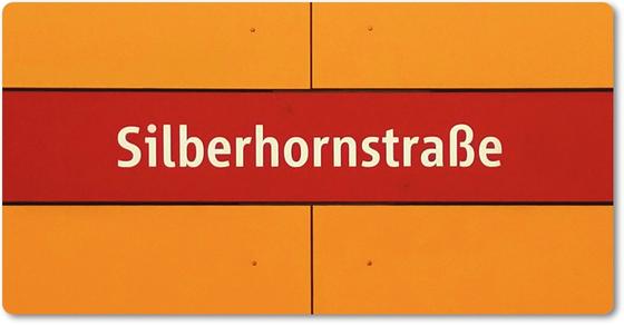 U-Bahnhof Silberhornstraße Kühlschrankmagnet - weiße Schrift auf rotem Streifen, vor dunkelgelbem Hintergrund