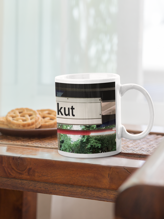 U-Bahn Kaffeebecher Kaffeetasse U-Bahnhof Kiekut schwarze schrift auf weißem frei schwebendem schild im hintergrund Bäume und Geäst