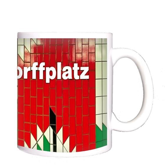 U-Bahnhof Mierendorffplatz Kaffeetasse - weiße Lettern auf roter Fliesenwand mit abstraktem Muster aus weißen, grünen und schwarzen Dreiecken
