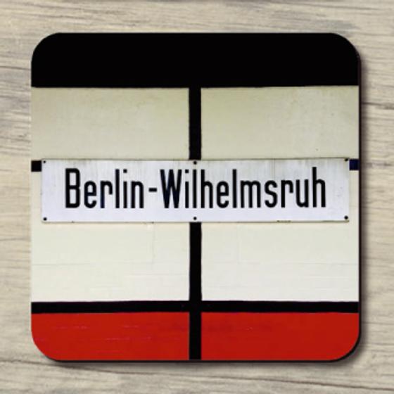 S-Bahnhof Berlin-Wilhelmsruh - schwarze Schrift auf weißem Schild im Hintergrund schwarz, weiß und rot
