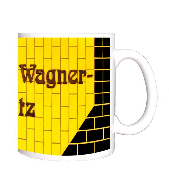 U-Bahnhof Richard-Wagner-Platz U-Bahn Souvenir Kaffeetasse - braune, verschlungene Schrift auf gelbem Kachelhintergrund, umrandet von schwarzen Kacheln