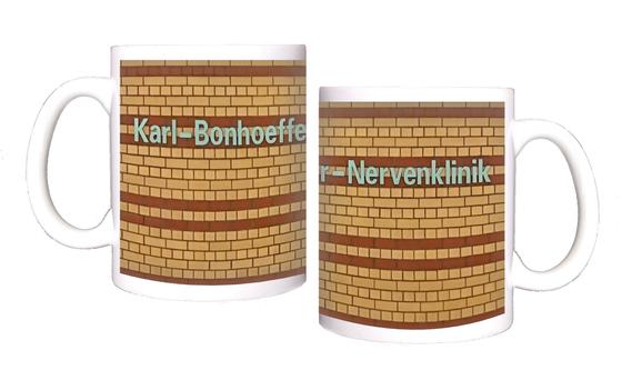 U-Bahnhof Karl-Bonhoeffer-Nervenklinik Kaffeetasse - weiße Lettern auf gelbem Backsteinhintergrund mit rötlich-braunen Streifen