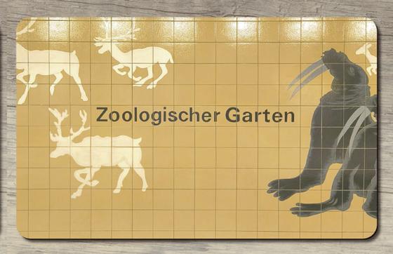 U-Bahnhof Zoologischer Garten Frühstücksbrettchen schwarze Schrift auf gelben Kacheln, darauf Seelöwen und Elche
