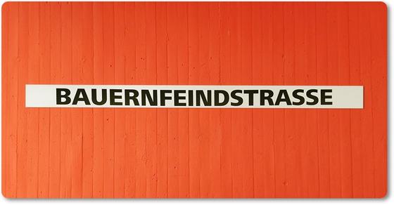 U-Bahn-Magnet Nuernberg Bauernfeinstrasse der Linie U1 in der originalgetreuen Stations-Gestaltung - schwarze Schrift auf weißem Streifen, oranger Streifenbeton Hintergrund 