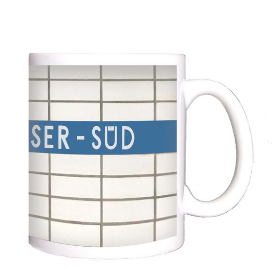 U-Bahn-Tasse Nuernberg Langwasser-Süd der Linie U1 in der originalgetreuen Stations-Gestaltung - weisser Fliesenspiegel mit weisser Schrift auf hellblauem Streifen