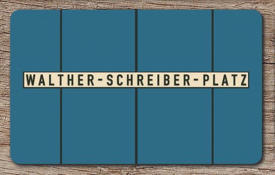 U-Bahnhof Walther-Schreiber-Platz in der originalgetreuen Stations-Gestaltung bis 2015 - schwarze Schrift auf weißem Streifen vor blauem Hintergrund mit schwarzem Streifen