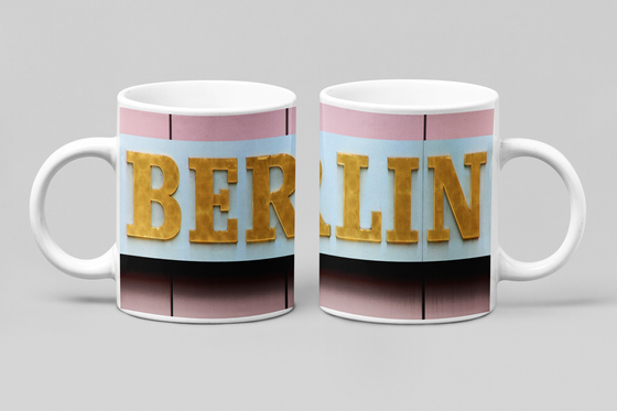 Foto eines goldenem Berlin-Schriftzugs vor einer pinken Wand. 