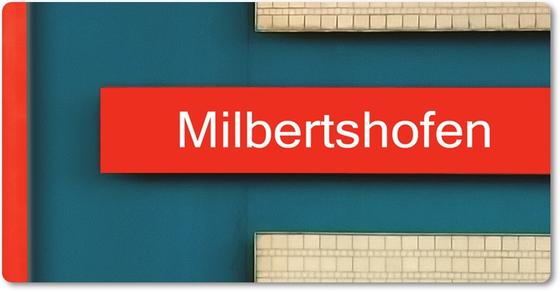 U-Bahn-Magnet Milbertshofen der Muenchner Linie U2 in der originalgetreuen Stations-Gestaltung - petrolblaue Rückwand mit einzelnen weissen Klinkermosaikflaechen mit weisser Schrift auf rotem Balken