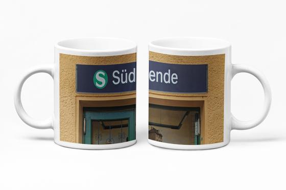 S-Bahnhof Südende S26 Kaffeetasse - weisse Schrift auf blauem Schild über Eingangstür - Umrahmt von beige-brauner Rauputz-Wand