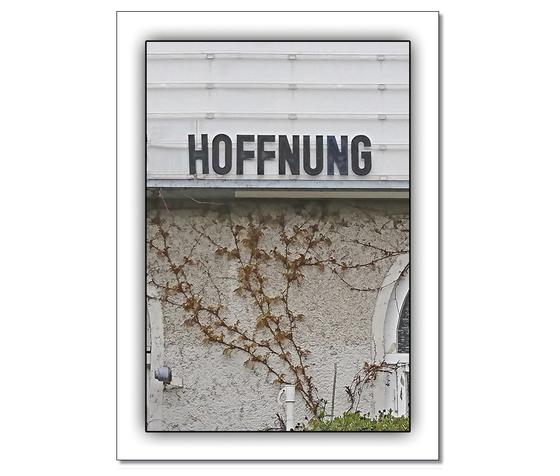 Klassische Postkarte - Dunkler Schriftzug HOFFNUNG in Großbuchstaben auf einer old-fashioned weißen Kino Leuchttafel an einer Hauswand mit weitestgehend blattloser Efeuranke